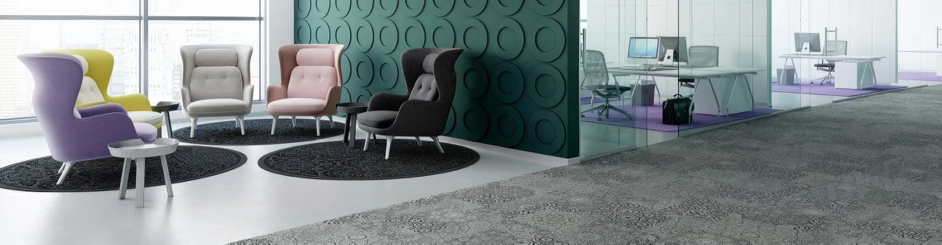 Bild Aktuelles: Modernes Bürointerieur mit einer Reihe Sessel in unterschiedlichen Polsterstoffen vor einer grün strukturierten Wand und Teppichboden mit Muster.